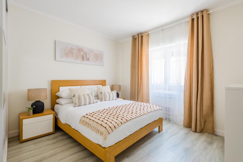 um quarto com uma cama e uma janela em Bela Vista B em Lisboa