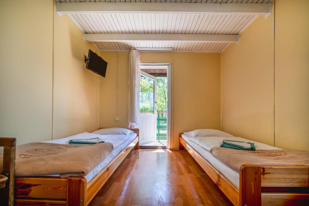 two beds in a room with a window at OW Gromada Pod Topolami in Międzyzdroje