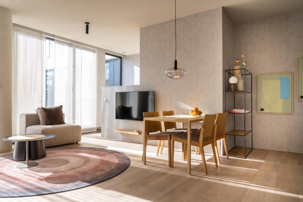 ein Wohnzimmer mit einem Tisch und Stühlen sowie einem TV in der Unterkunft 348 Suites Short Stay in Den Haag