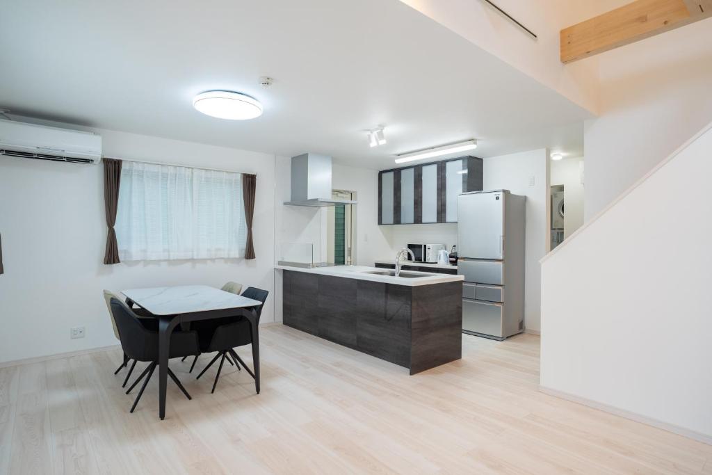 a kitchen with a table and a sink and a refrigerator at Comfy Resort Villa Onna in Onna