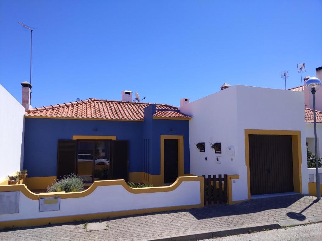 una casa azul y blanca con una valla en Comporta beach house en Carvalhal