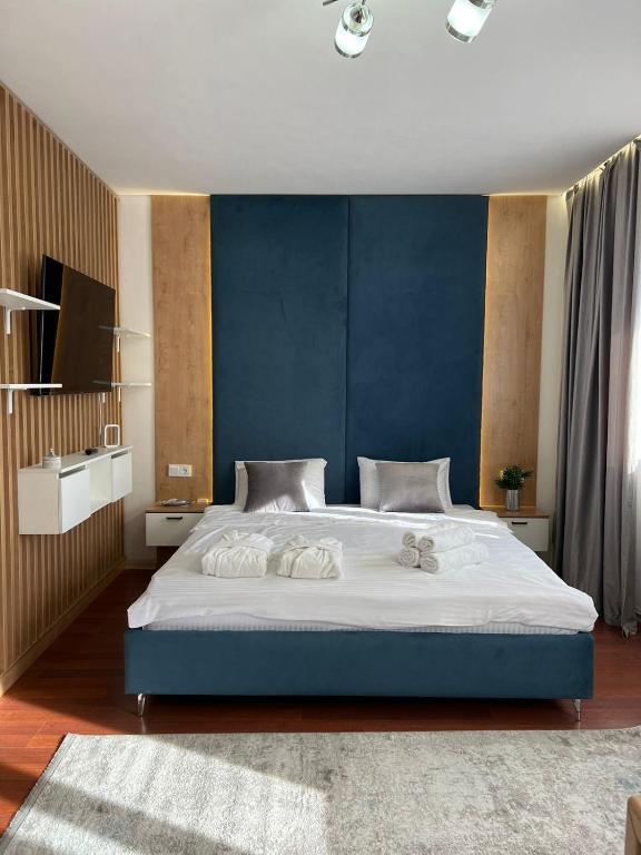 a bedroom with a large bed with a blue wall at Altai Apartments in Astana