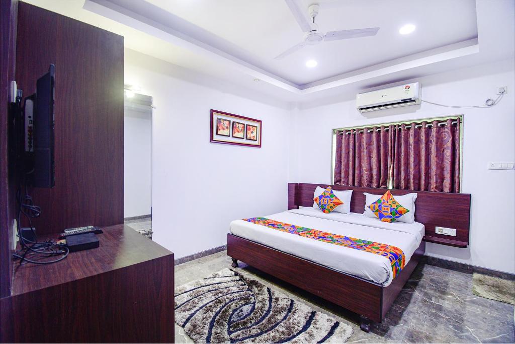 a bedroom with a bed and a television in it at FabHotel Rani Tower in Kolkata