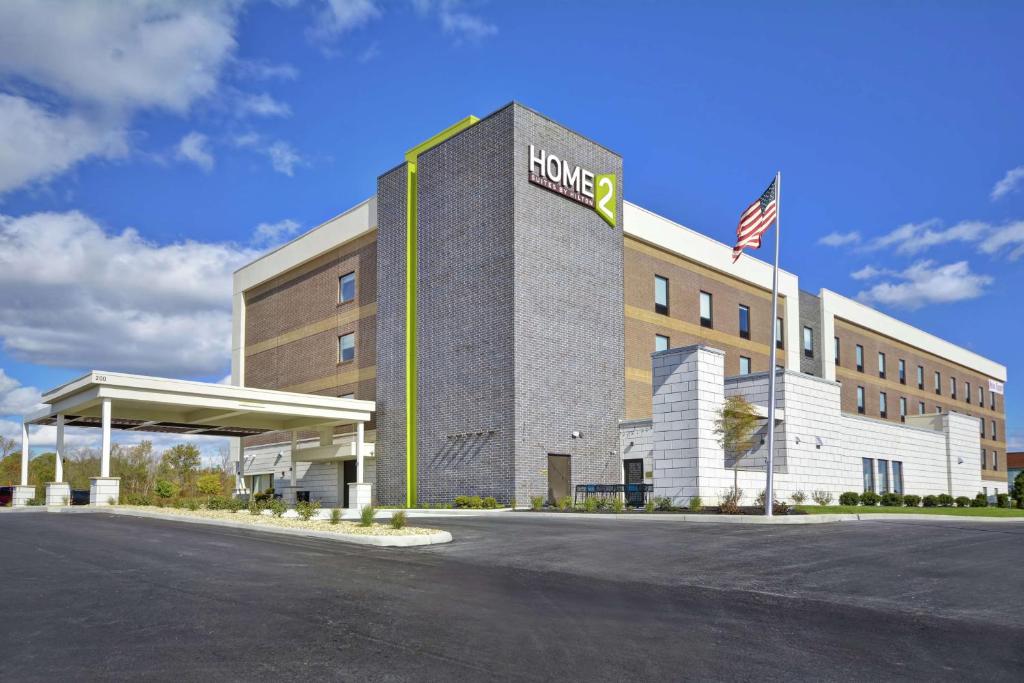 a hotel building with an american flag in front of it at Home2 Suites By Hilton Dayton South in Miamisburg