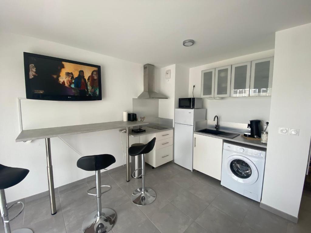 eine Küche mit einer Theke, einer Spüle und einer Waschmaschine in der Unterkunft APPARTEMENT TYPE 2 NEUF +GRANDE TERRASSE in Le Lavandou