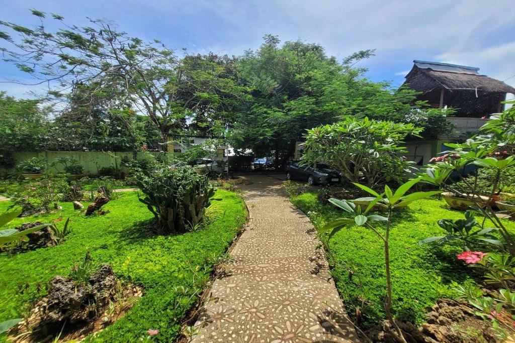 einen Garten mit einem Weg zum Haus in der Unterkunft Hanbee's Resort in Puerto Princesa