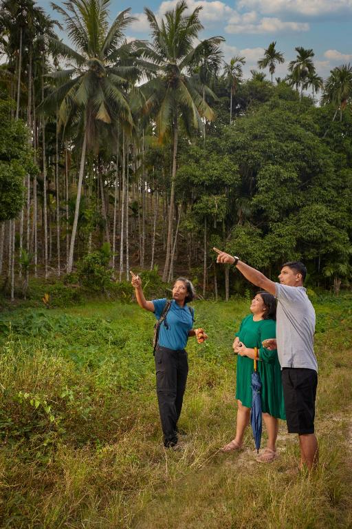 a group of people standing in a field with their arms in the air at Taj Exotica Resort & Spa, Andamans in Havelock Island
