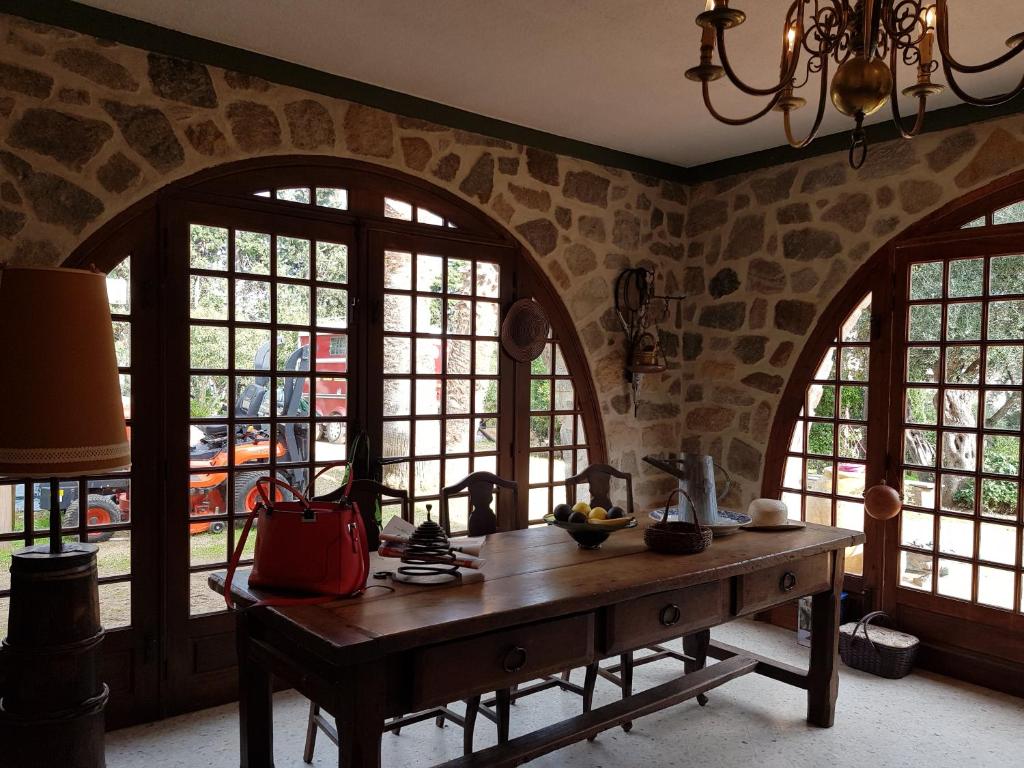 une cuisine avec des fenêtres cintrées et une table en bois dans l'établissement Nouveautés 2025 du clos-La Tonnelle, à Calvi