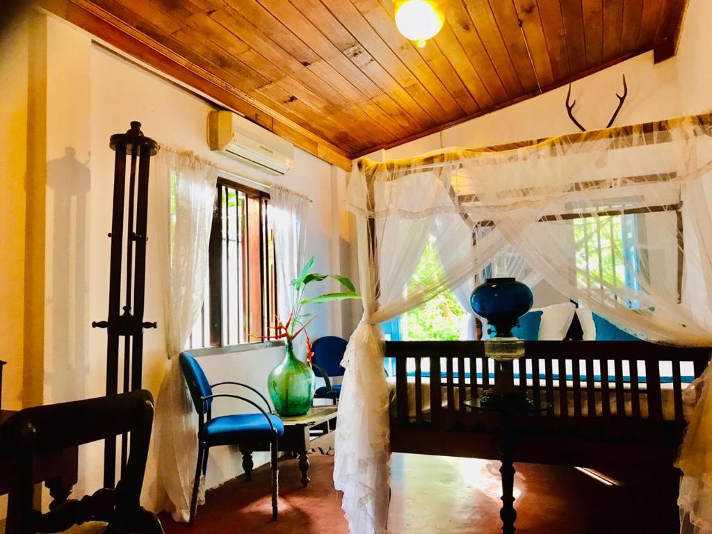 ein Esszimmer mit einem Tisch und einem Fenster in der Unterkunft Museum Villa 09 in Beruwala