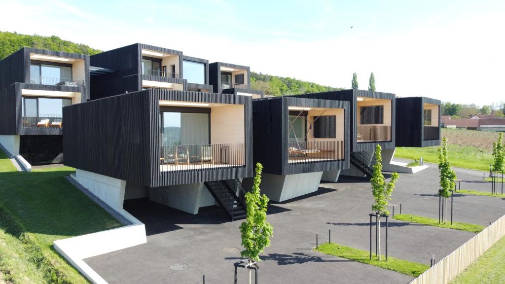 an architectural rendering of a black building with trees at Stock & Stein Lodges in Bad Gleichenberg