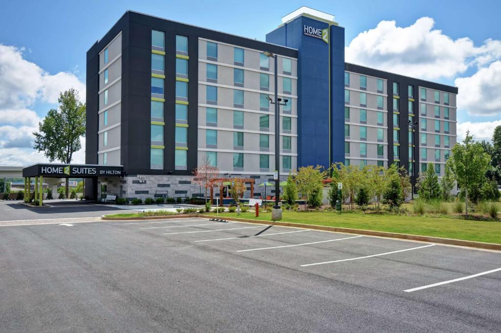 un grand bâtiment avec un parking en face de celui-ci dans l'établissement Home2 Suites By Hilton Atlanta Marietta, Ga, à Marietta