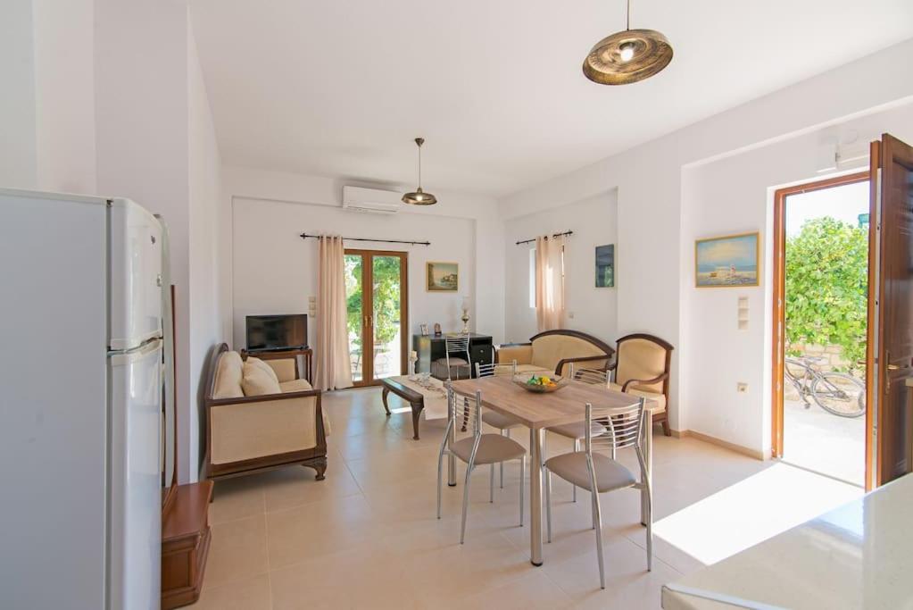 a kitchen and living room with a table and chairs at New Apt Close to Medical Center with Garden in Heraklio Town
