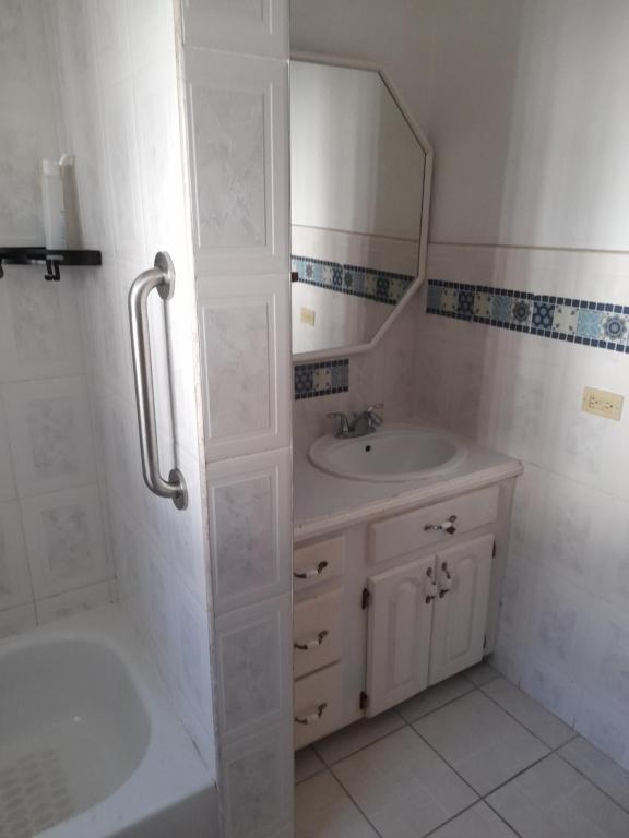 La salle de bains est pourvue d'une baignoire, d'un lavabo et d'un miroir. dans l'établissement Melrose Place, à Montego Bay