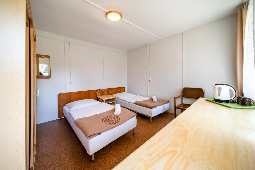 a hospital room with two beds and a chair at OW Gromada Pod Topolami in Międzyzdroje