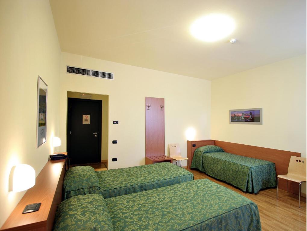Ένα ή περισσότερα κρεβάτια σε δωμάτιο στο Dama Hotel