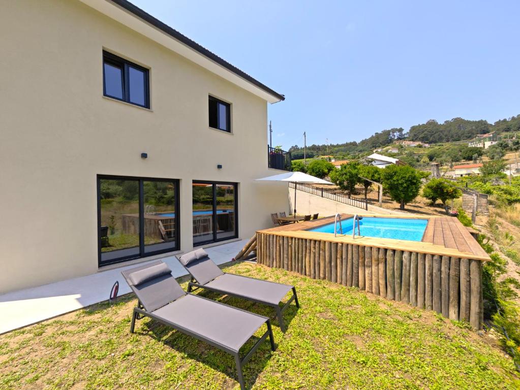a view of the backyard of a house with a swimming pool at Casa da Milinha - Villa with a Pool near Rio Douro in Santa Cruz do Douro