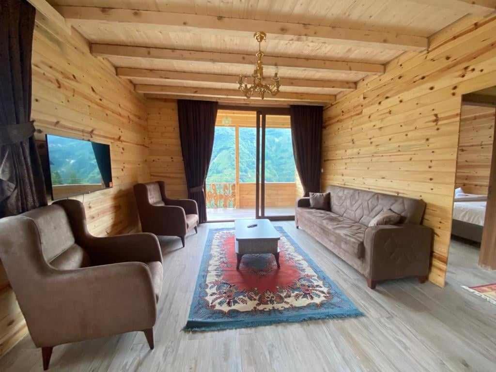uma sala de estar com dois sofás e uma mesa em KIRSULA DAĞ EVİ em Çamlıhemşin