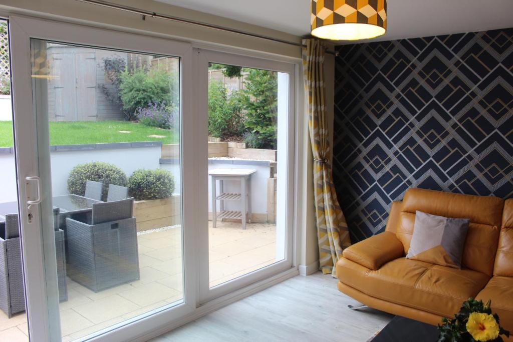 a living room with a sliding glass door at Modern Property Near Chichester & Goodwood Events with Garden, Great for Families! in Chichester