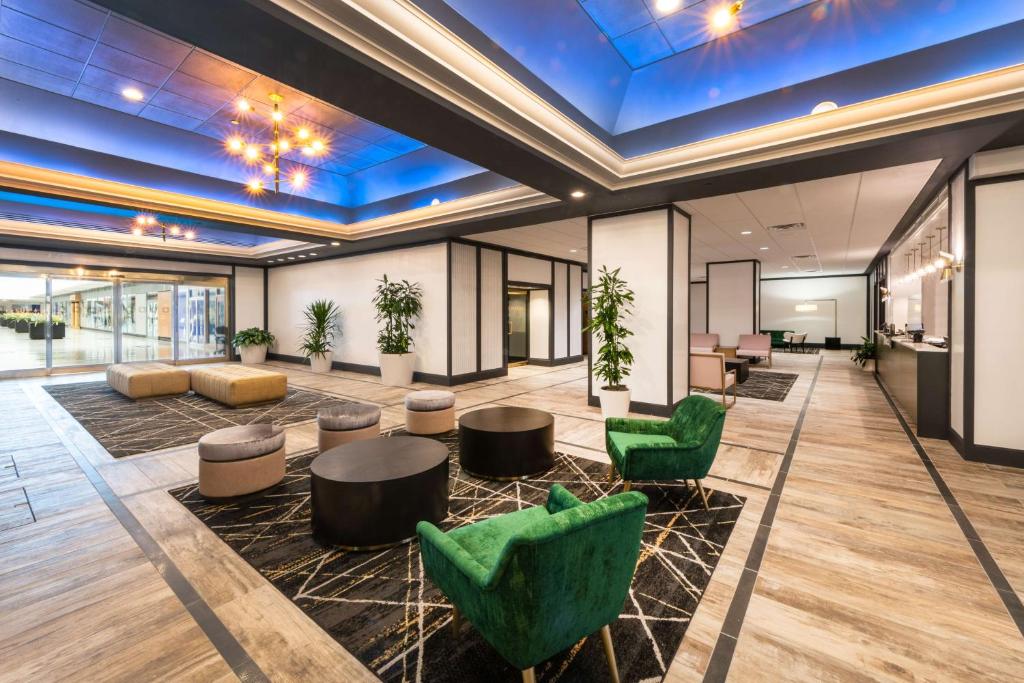 an office lobby with green chairs and tables at DoubleTree by Hilton Newark Penn Station, NJ in Newark