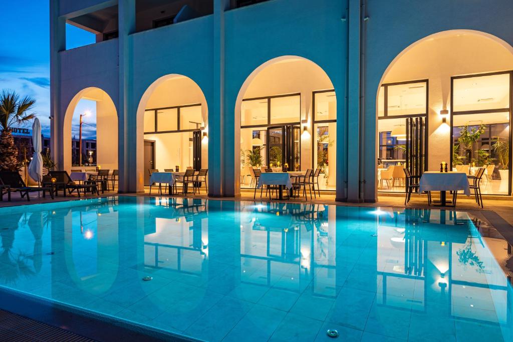 a swimming pool with tables and chairs in a building at Miramare Hotel in Zadar