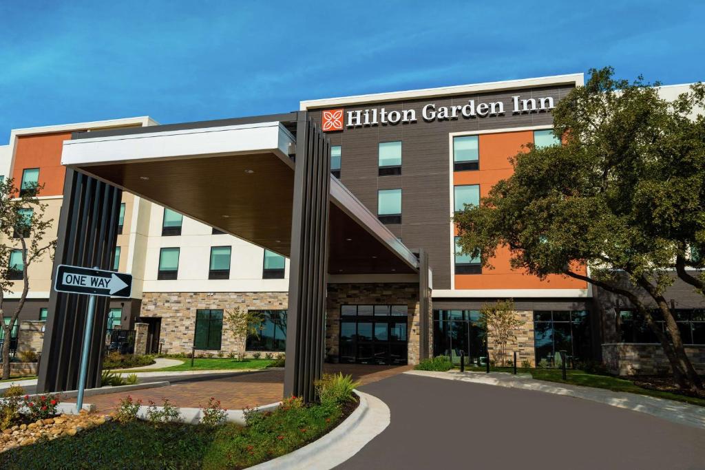 un edificio de oficinas con entrada a una posada con jardín en Hilton Garden Inn Cedar Park Austin, en Austin