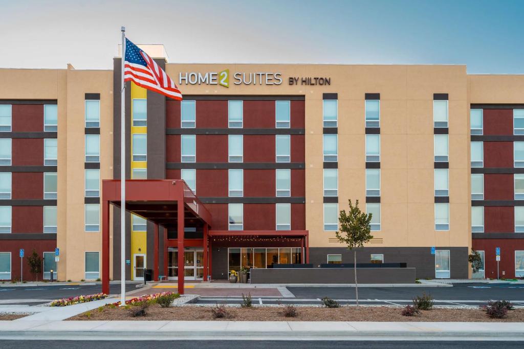 Um edifício com uma bandeira americana à frente. em Home2 Suites Bakersfield em Bakersfield