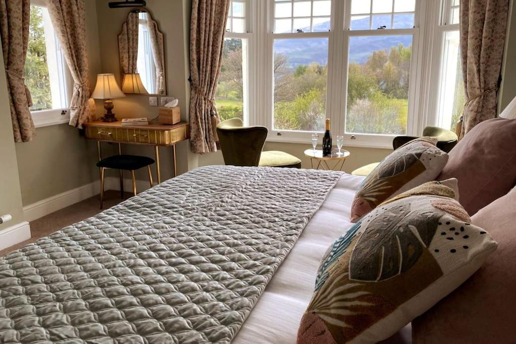 a bedroom with a large bed in front of a window at Barf Fell House in Bassenthwaite Lake