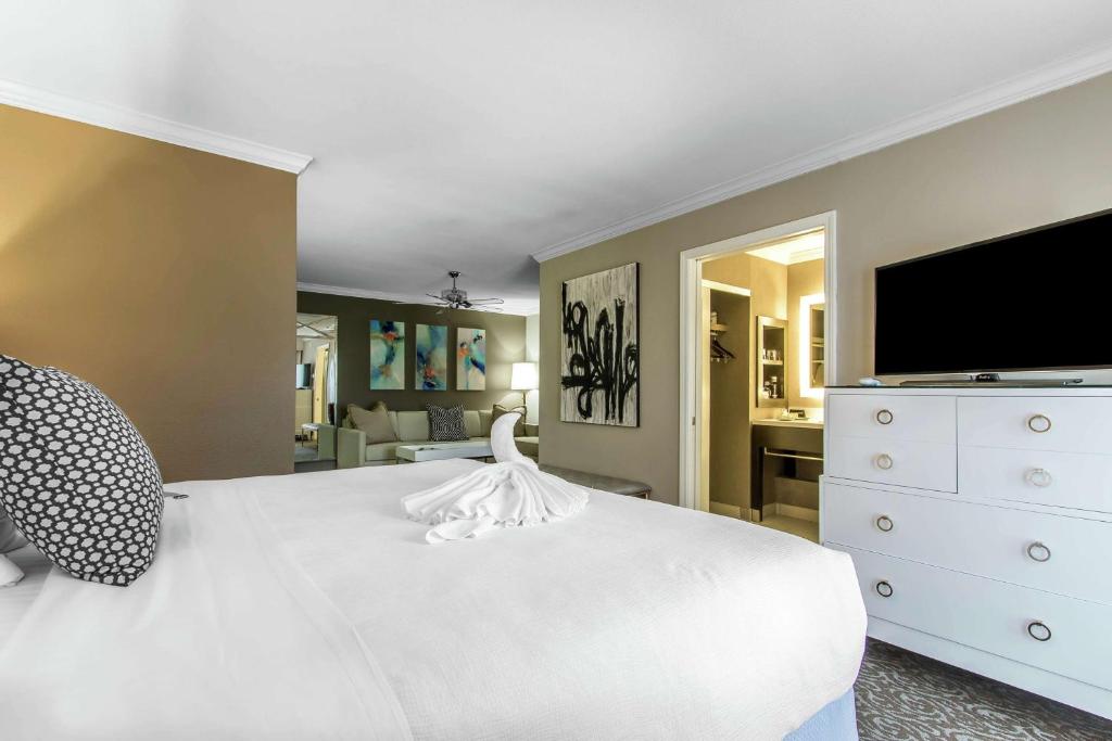 The Burgundy Hotel, Tapestry Collection by Hilton في ليتل روك: غرفة نوم بسرير ابيض وتلفزيون بشاشة مسطحة