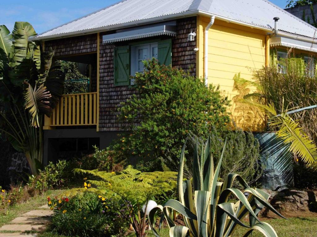 a yellow house with a garden in front of it at LES CASES METISSES in Saint-Louis