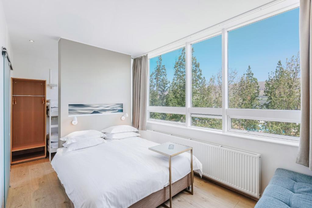 a bedroom with a bed and large windows at Akureyri - Berjaya Iceland Hotels in Akureyri