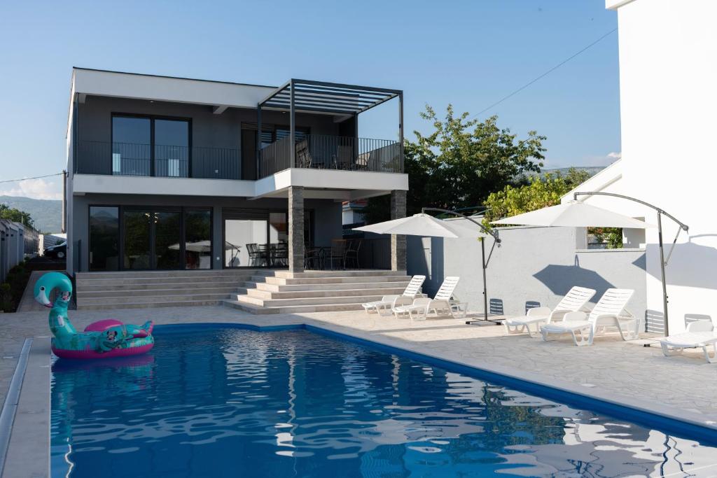 una casa con piscina con fideos frente a ella en Villa Zulfikar, en Mostar