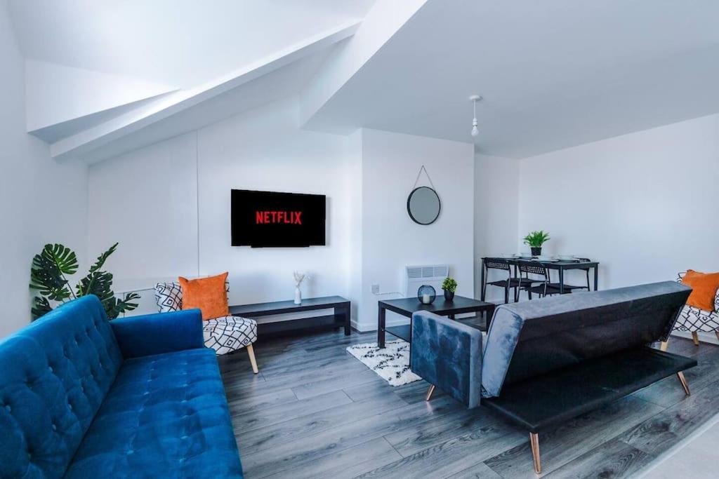 a living room with a blue couch and a tv at Beautiful apartment una in Litherland