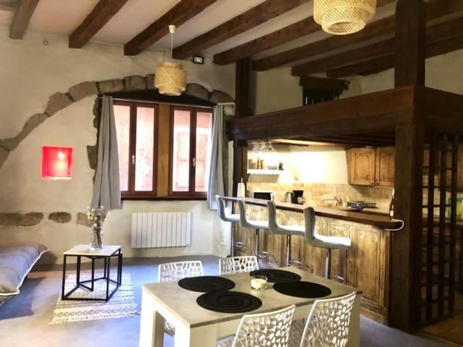 une pièce avec une table et des chaises et une cuisine dans l'établissement L'atypique, bord du Thiou, à Annecy