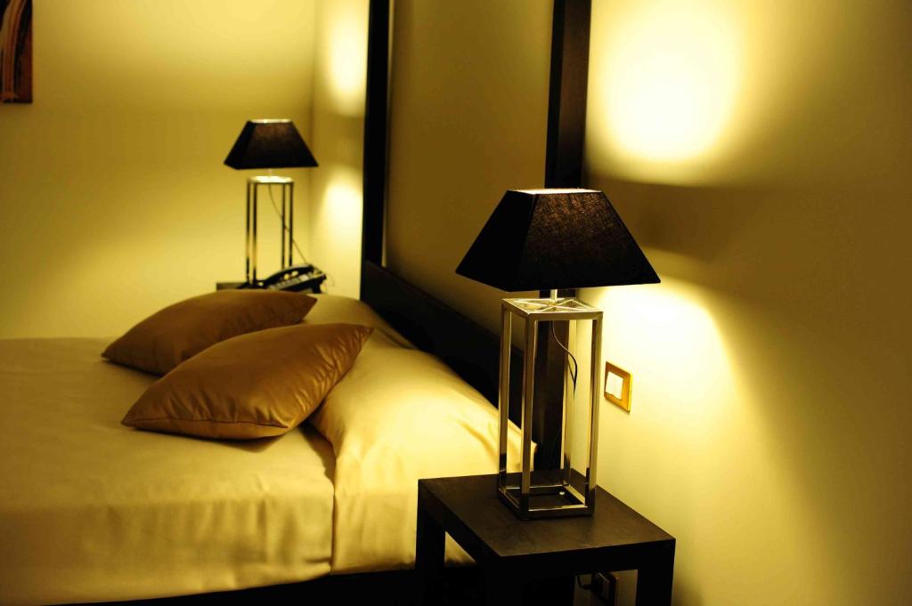 a bedroom with a bed with a lamp on a table at La Civetta in Foggia