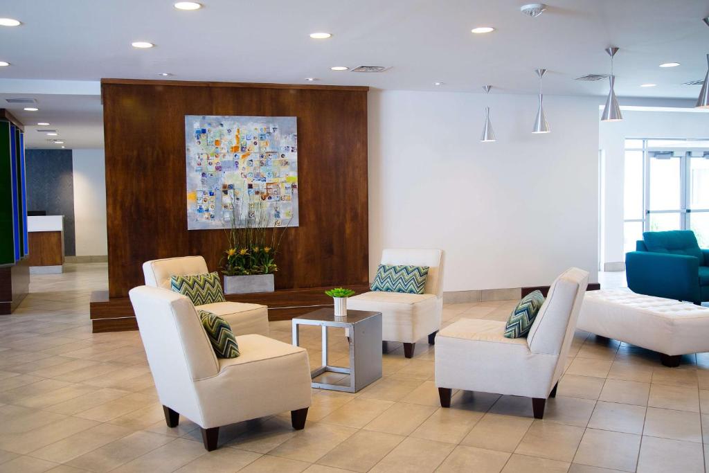 a waiting room with chairs and a painting on the wall at Doubletree By Hilton Omaha Southwest, Ne in Omaha