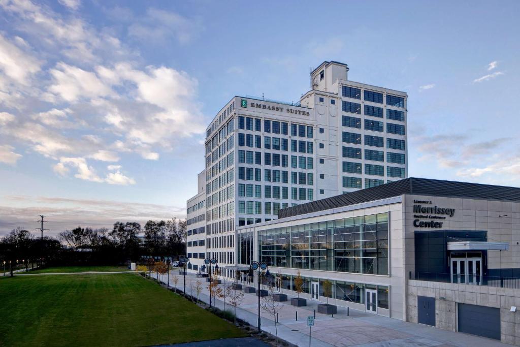 um grande edifício de escritórios com um relvado em frente em Embassy Suites By Hilton Rockford Riverfront em Rockford