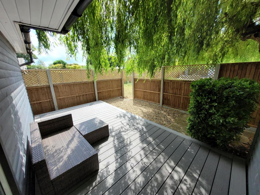 a patio with two benches on a wooden deck at Willow Inn in Kent