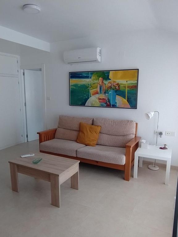 una sala de estar con sofá y una pintura en la pared en ÁTICO CENTRO, en Yecla