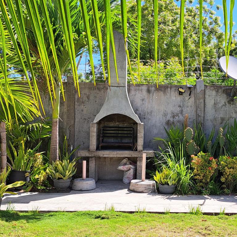 un forno in pietra in un giardino con piante di Mirka's Guest House a Isola di Bantayan