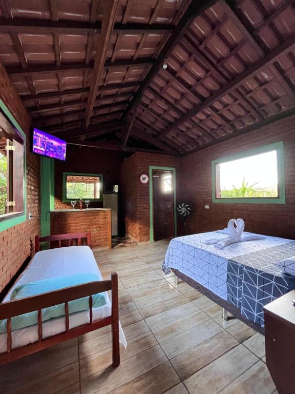 ein Schlafzimmer mit 2 Betten und einem TV in der Unterkunft Sítio do pica pau amarelo in São Thomé das Letras