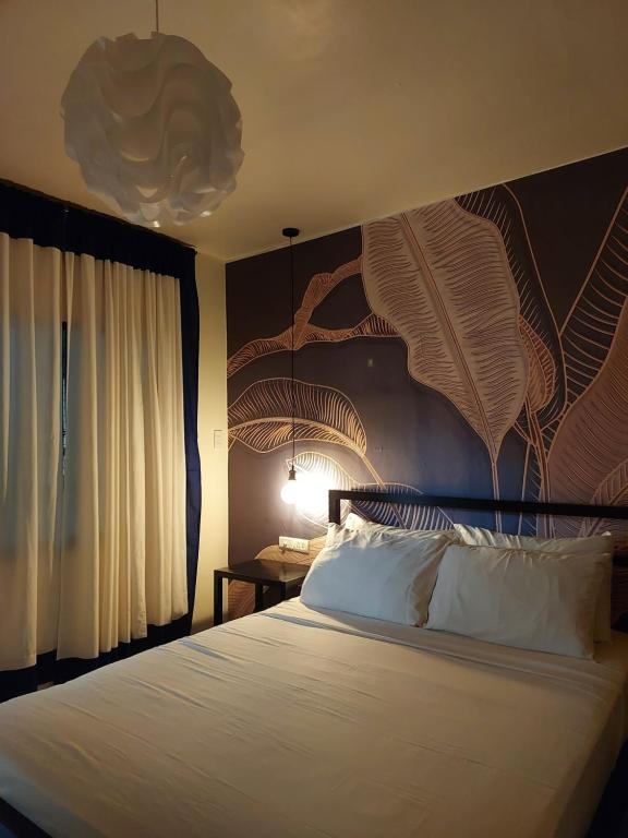 a bedroom with a large bed with a large headboard at MOHO in Moalboal