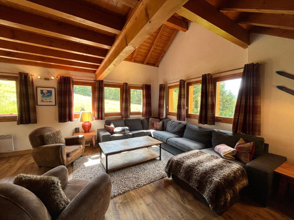 a living room with a couch and chairs and windows at Chalet Pic Blanc Alpe d’Huez/Oz en Oisans in Oz