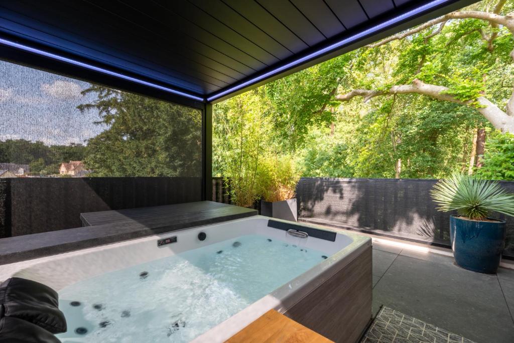 a jacuzzi tub on a patio with a window at La Kabann in Oissel