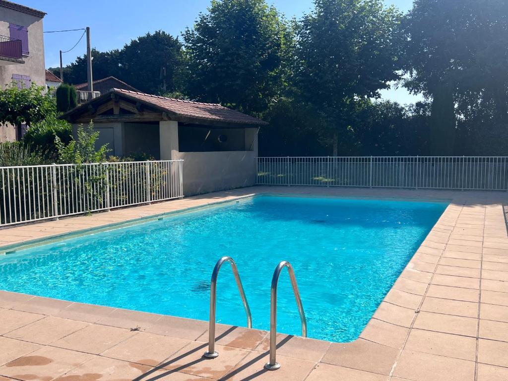 ein blauer Pool mit zwei Metallschienen in der Unterkunft Appartement T2 avec jardin privé, piscine et barbecue in Lorgues