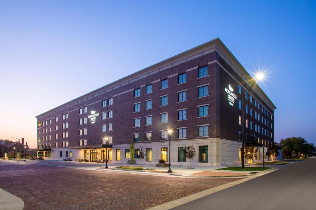 a large brick building on a street at night at Homewood Suites By Hilton Salina/Downtown, Ks in Salina