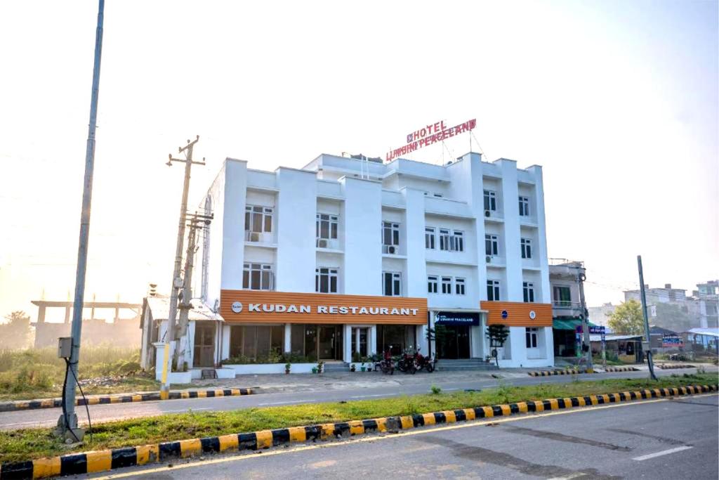 a white building on the side of a street at Hotel Peaceland Lumbini in Lumbini