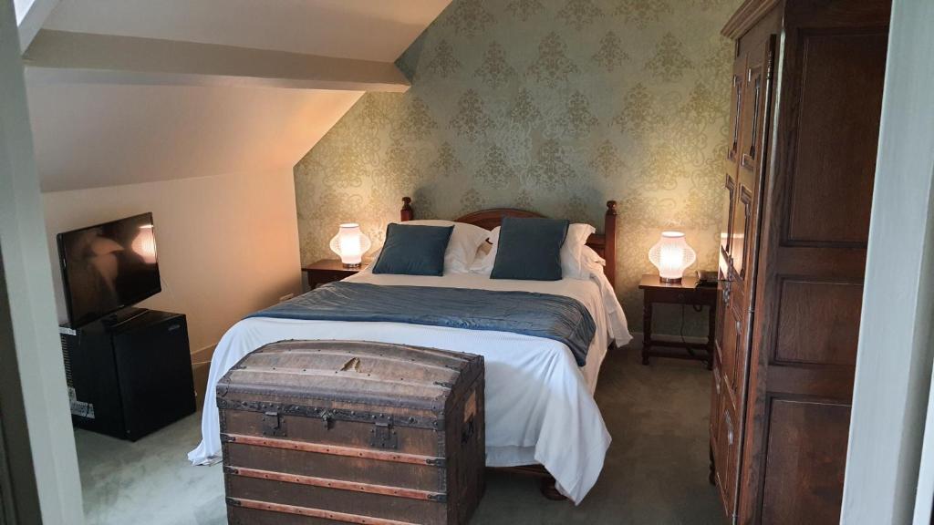 a bedroom with a large bed and two night stands at LOGIS - Hôtel & Restaurant Le Gonfalon in Germigny-lʼEvêque