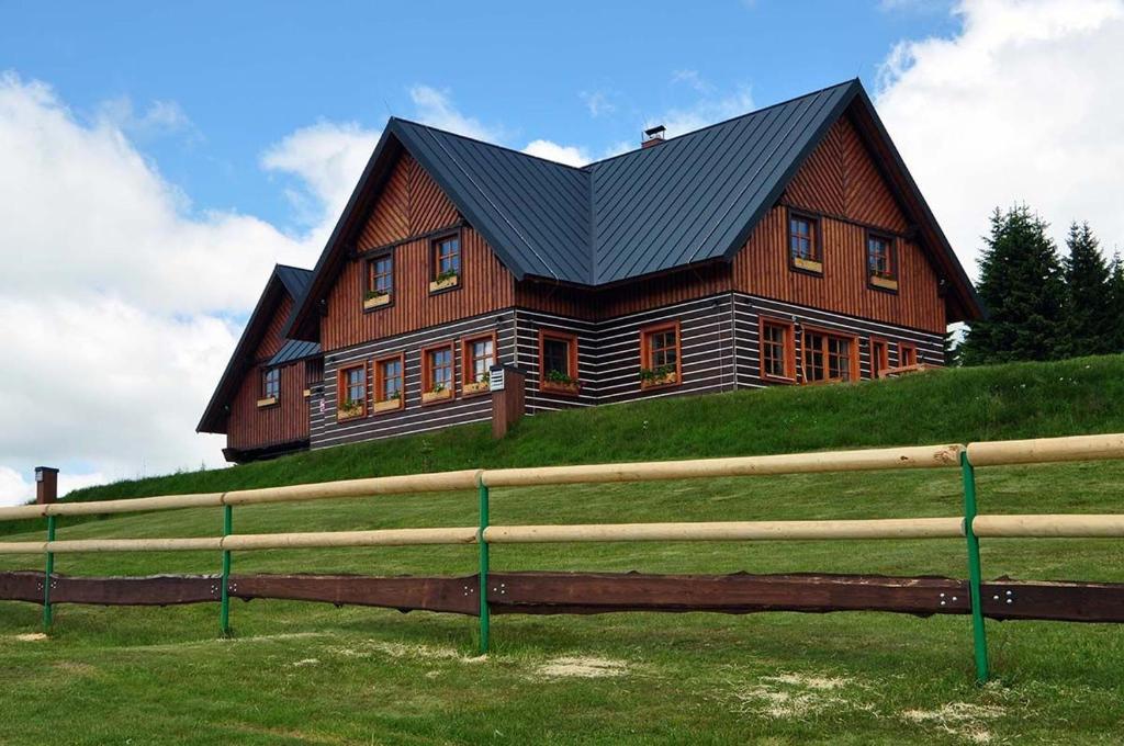 uma grande casa de madeira no topo de uma colina em Hotel Vydrovy Boudy em Pec pod Sněžkou