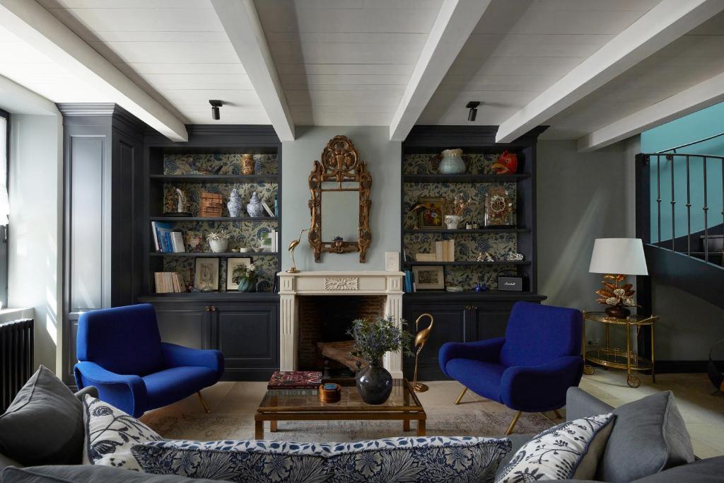 ein Wohnzimmer mit blauen Stühlen und einem Kamin in der Unterkunft Maisons 322 - La Secrète in Le Bois-Plage-en-Ré