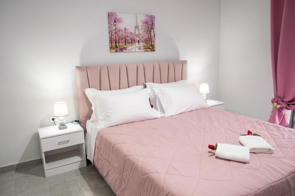トロにある3S Tolo Apartmentsのベッドルーム1室(ピンクベッド1台、タオル2枚付)